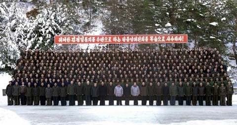 Bức ảnh này, được KCNA đăng tải ngày 13/12/2011, ông Kim Jong-il (giữa, đeo kính) chụp với các nhân viên của một nhà máy con của Liên hợp Cơ khí Ryongsong ở Hamhung.